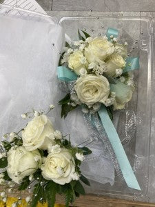 White and powder blue wrist corsage and boutonniere
